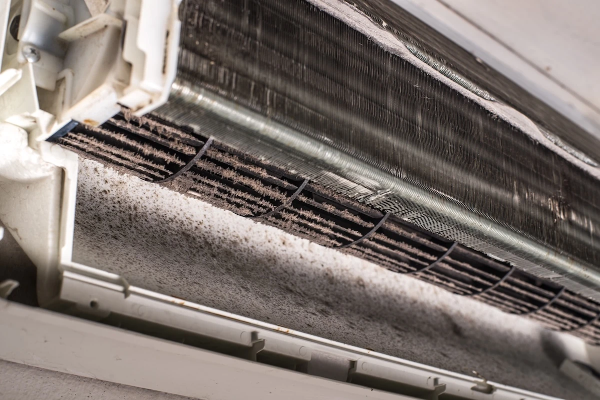 Air conditioner interior with accumulated dirt on the coil and air outlet